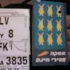 Luggage tag from JFK to TLV (Tel Aviv) and a card saying MASHKEH ASIRI CHINAM - 10th Drink Free.